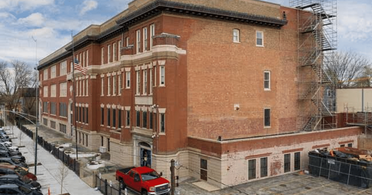 Escuela Primaria Hamline en Chicago con bandera de EE.UU. y vehículos estacionados