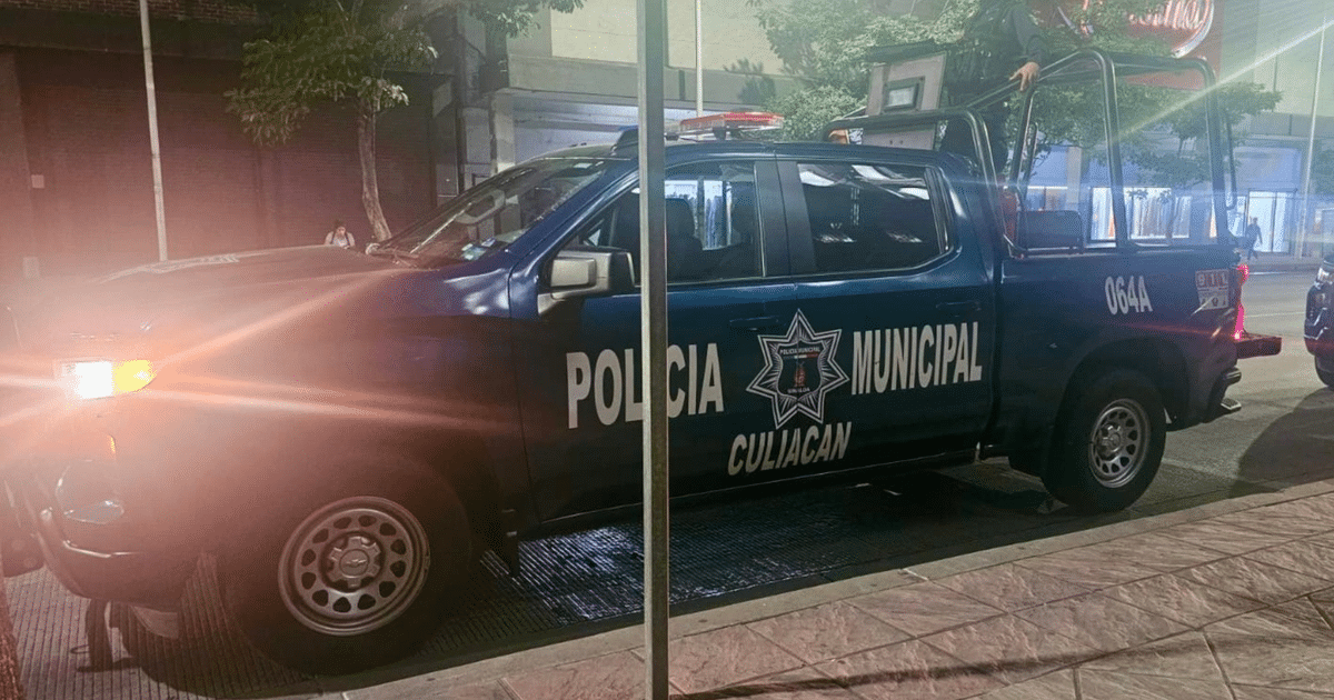 Camioneta de la Policía Municipal de Culiacán estacionada en una calle urbana de noche.