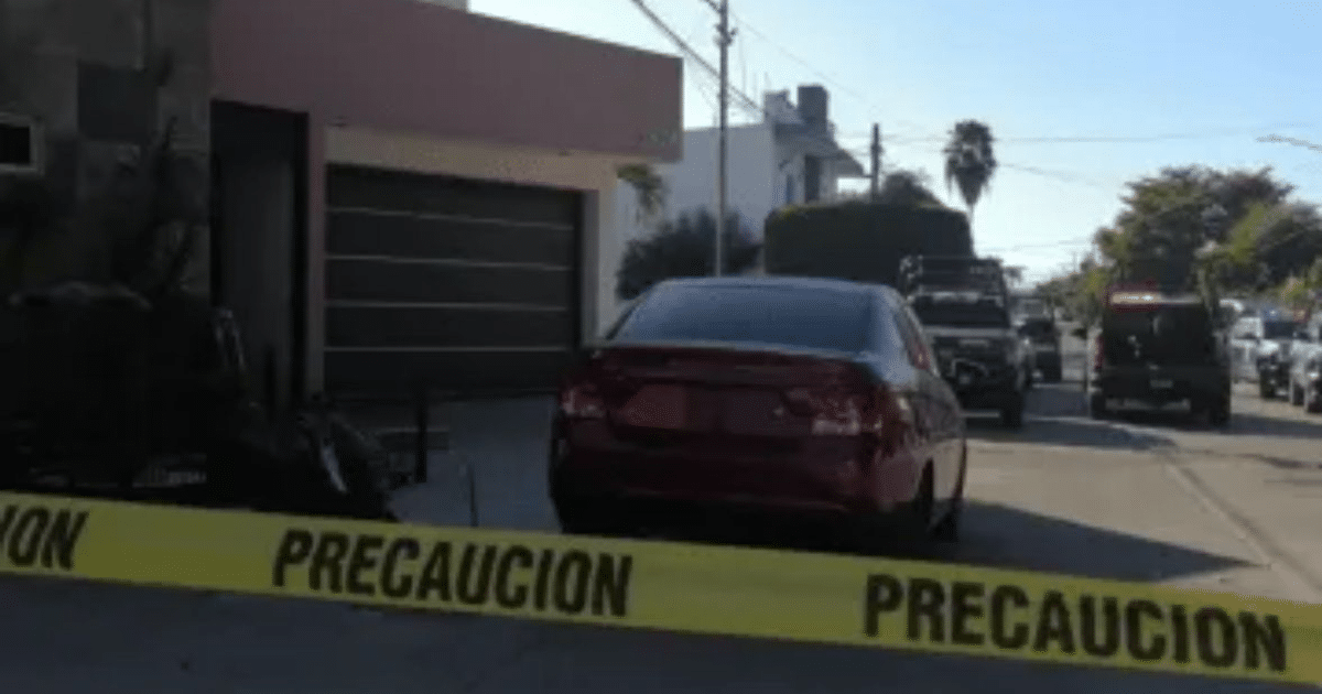 Cinta de precaución amarilla en escena del crimen en Culiacán con automóvil rojo y vehículos policiales