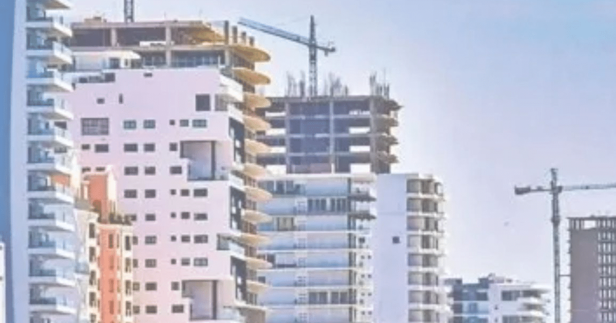 Edificios modernos en construcción en Mazatlán con grúas y cielo despejado.