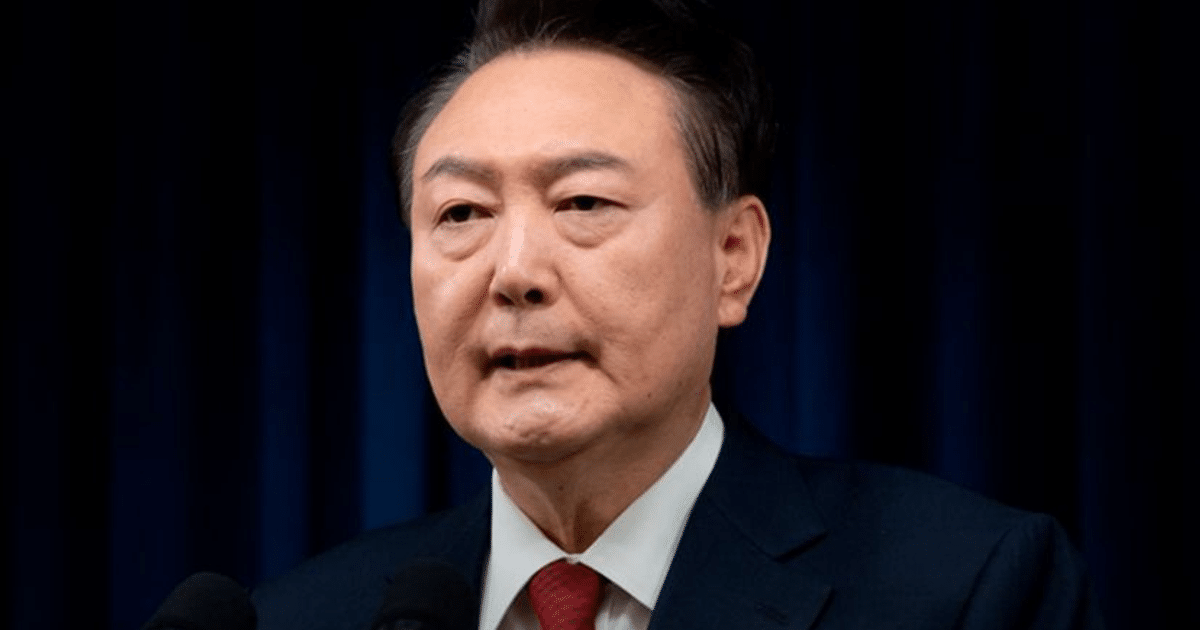 Hombre en traje oscuro hablando en un evento formal, relacionado con la detención de Yoon Suk Yeol en Corea del Sur.