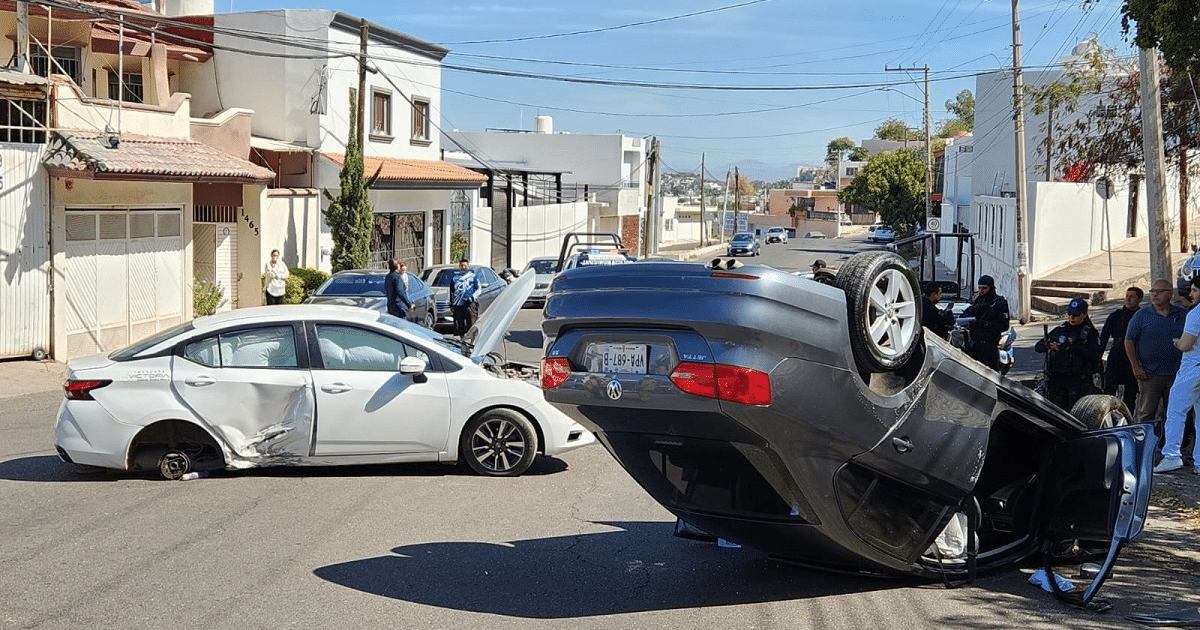 Accidente de tráfico en Culiacán con vehículo volcado y daños laterales en otro coche, rodeados de personal de emergencia.