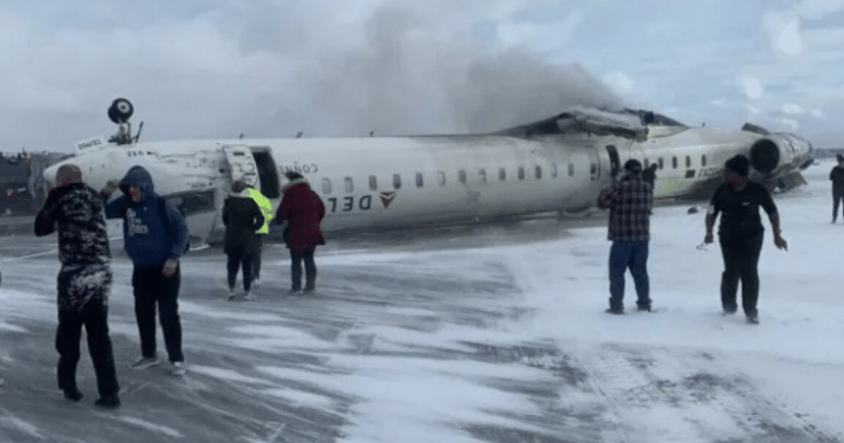 Avión volcado en pista del aeropuerto Pearson de Toronto con humo y espuma de extinción de incendios.