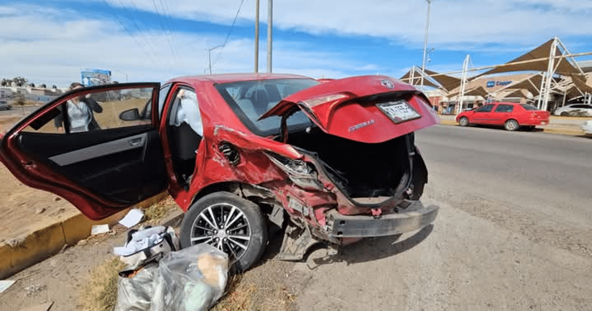 Automóvil rojo dañado en accidente de tránsito en Culiacán, con maletero abierto y objetos en el suelo.