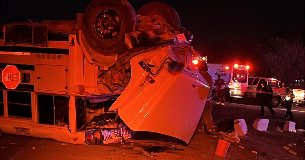 Vehículo volcado en accidente nocturno en Guasave, con luces de emergencia y rescatistas presentes.