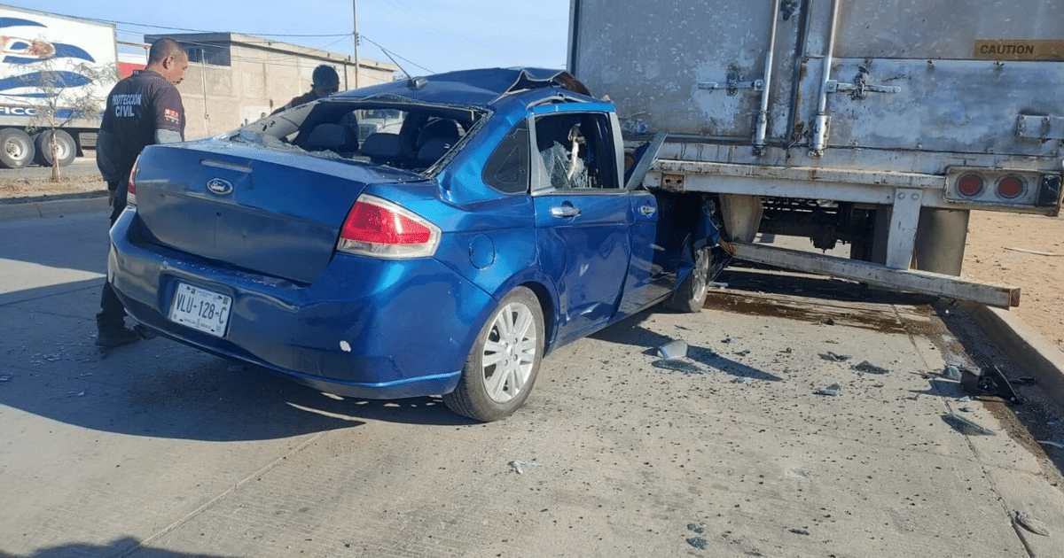 Accidente de tráfico en Los Mochis: coche azul colisionado con camión, escombros de vidrio y servicios de emergencia presentes.