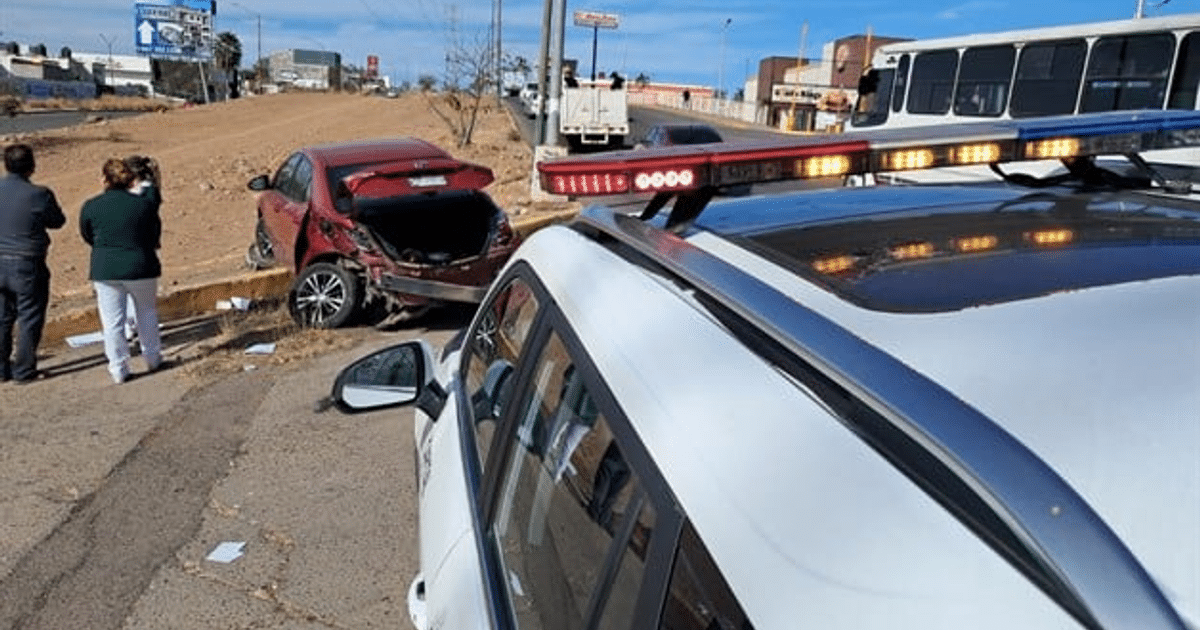 Automóvil rojo dañado en accidente vial en San Isidro, Culiacán, con presencia policial.