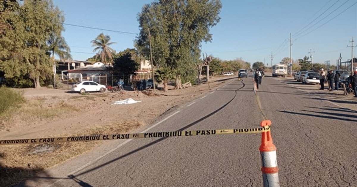 Escena de accidente en carretera con cinta de 'PROHIBIDO EL PASO' y personal de emergencia en Guasave.