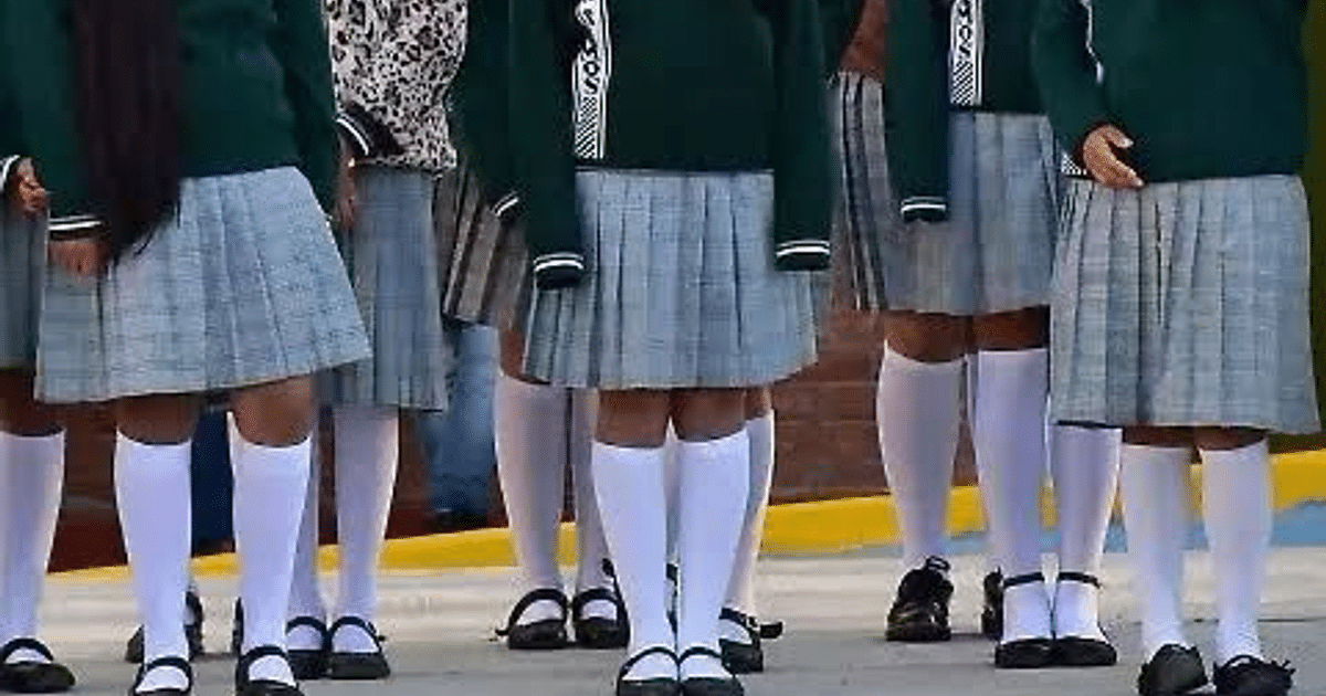 Grupo de estudiantes en uniforme escolar con faldas de cuadros y abrigos oscuros, en un contexto de acoso escolar en Iztapalapa.
