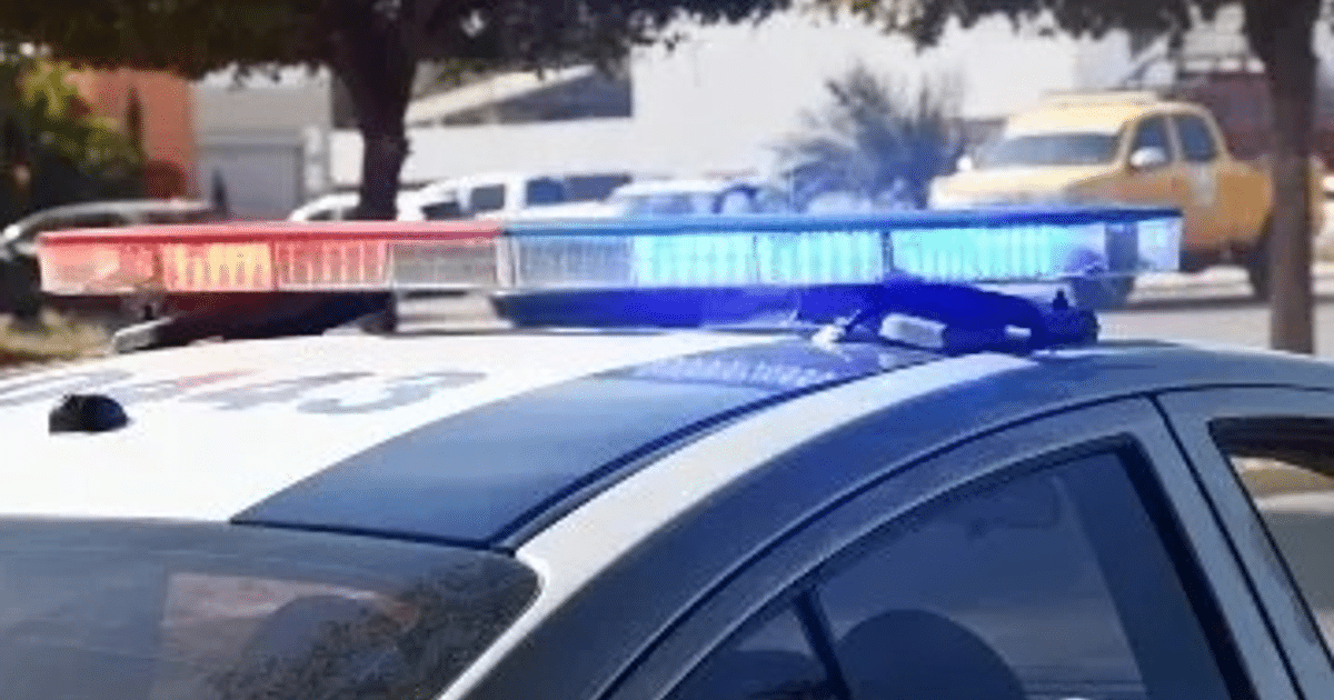 Coche de policía con luces de emergencia encendidas en Juan José Ríos, Sinaloa, durante un operativo por un ataque con arma blanca.