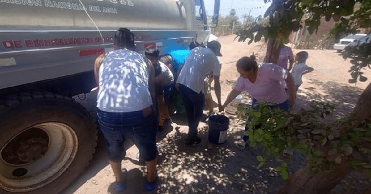 Personas recolectando agua cerca de un camión en un área rural de Ahome