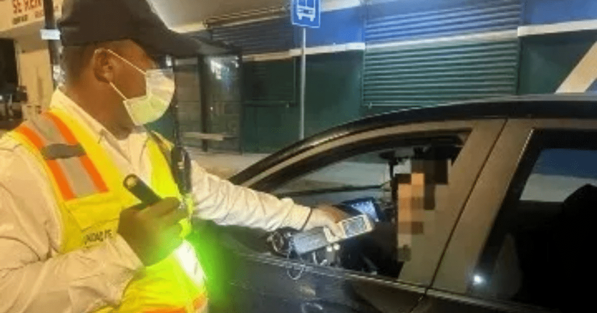 Agente de tránsito realizando prueba de alcoholímetro a conductor en Mazatlán durante operativo nocturno.
