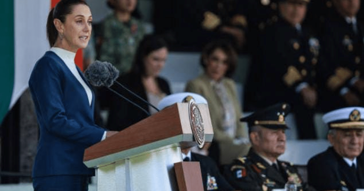 Claudia Sheinbaum hablando en un podio durante un evento oficial con banderas y militares de fondo.