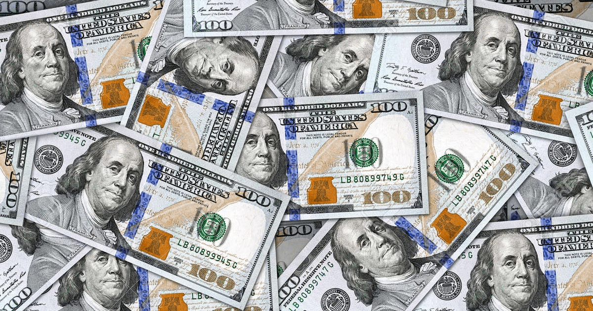 Billetes de cien dólares estadounidenses dispersos con la imagen de Benjamin Franklin.