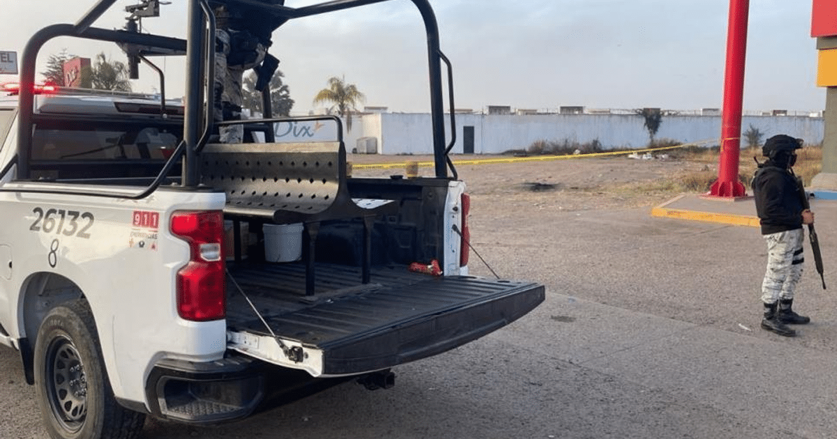 Camioneta pickup en escena de investigación con hombre armado y área acordonada en Culiacán.
