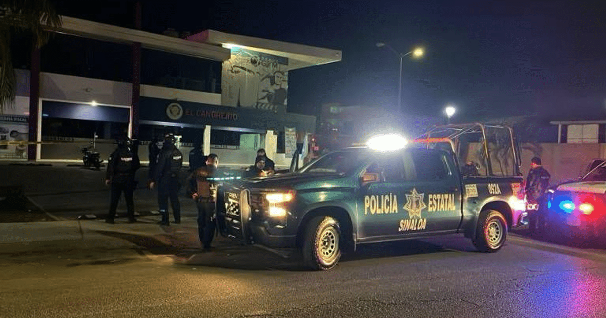 Vehículo policial con luces activas en escena de crimen nocturna en Culiacán, oficiales presentes.