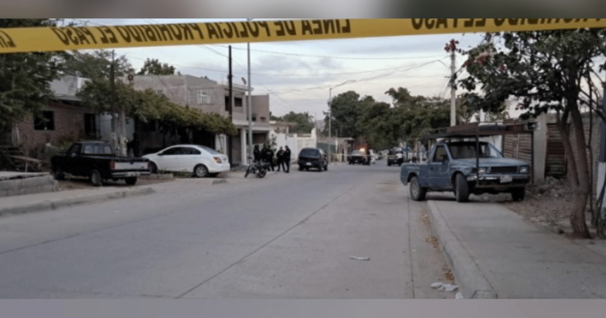 Calle en Culiacán con cordón policial y vehículos estacionados tras un incidente violento.