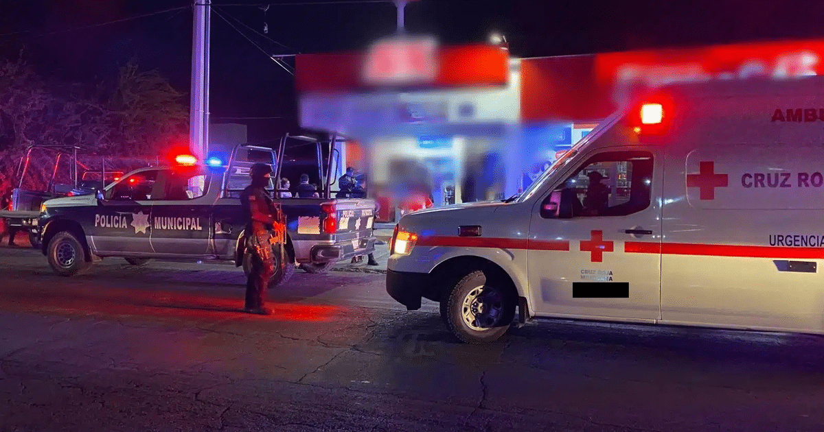 Ambulancia y camioneta de policía con luces intermitentes en escena nocturna de emergencia.