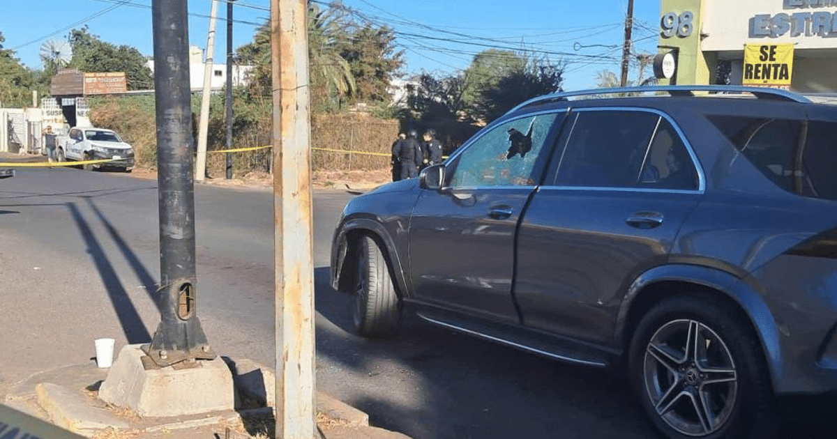 Coche gris con cristal roto en escena de investigación policial en Culiacán