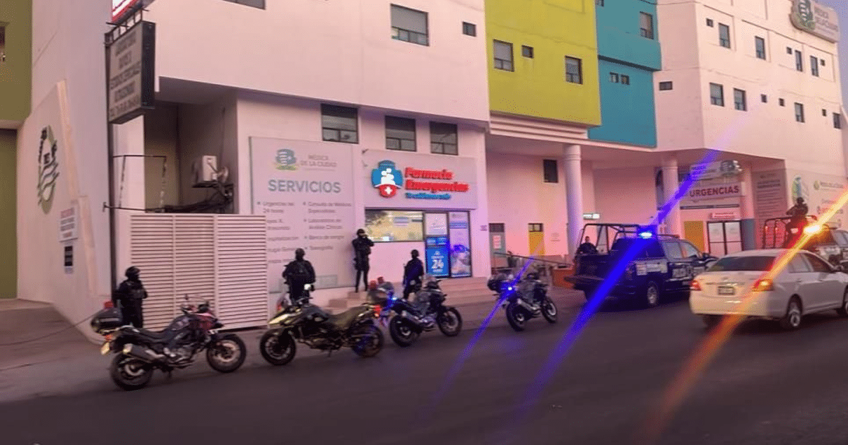 Policías armados y vehículos policiales frente a un centro de salud tras un incidente violento.