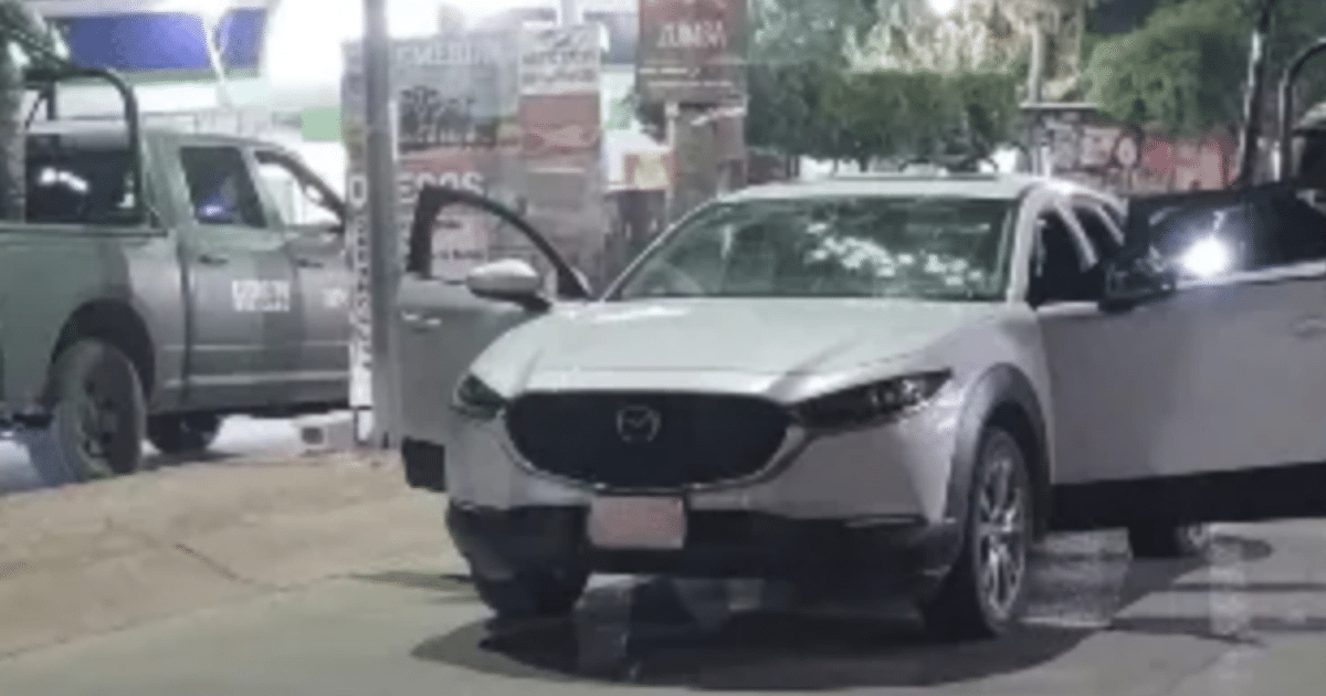 Automóvil Mazda plateado con puerta abierta en área urbana, relacionado con incidente de seguridad.