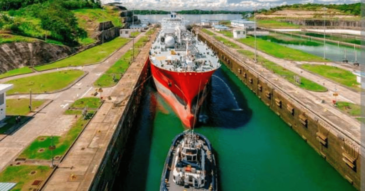 Barco grande en el Canal de Panamá asistido por remolcador, rodeado de estructuras de concreto y áreas verdes.