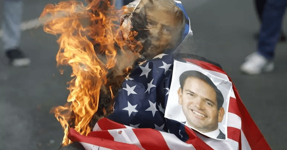 Objeto en llamas con bandera y retrato, simbolizando protesta en contexto diplomático.