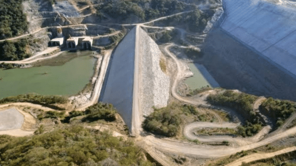 Vista de la presa Santa María en Los Mochis con estructura de tierra y cuerpo de agua, rodeada de montañas.