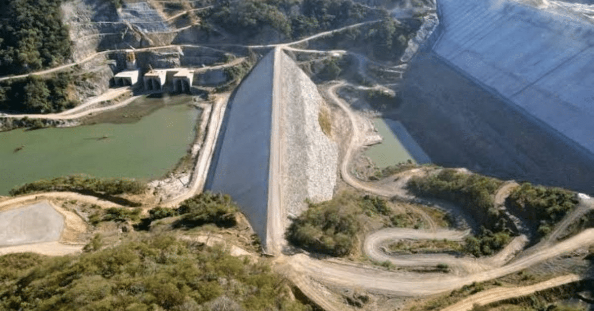 Vista de la presa Santa María en Los Mochis con estructura de tierra y cuerpo de agua, rodeada de montañas.
