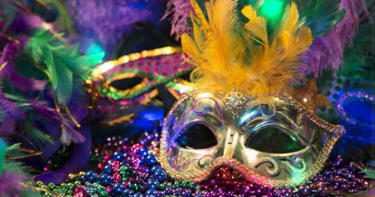 Máscara de carnaval con plumas amarillas y cuentas de colores sobre un fondo festivo.