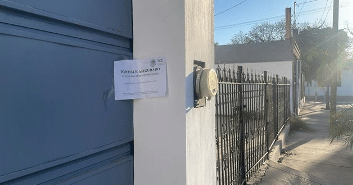 Puerta azul con aviso de inmueble asegurado en entorno urbano