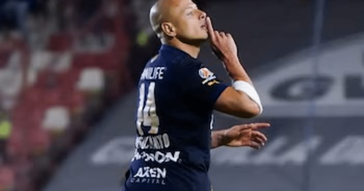 Jugador de fútbol con camiseta oscura número 14 celebrando un gol con gesto de silencio en el estadio Alfonso Lastras.