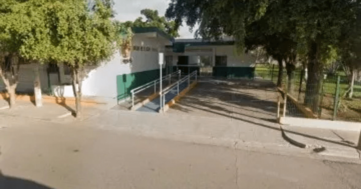 Edificio accesible con rampa en Pericos, Mocorito, rodeado de árboles y con fachada blanca y verde.