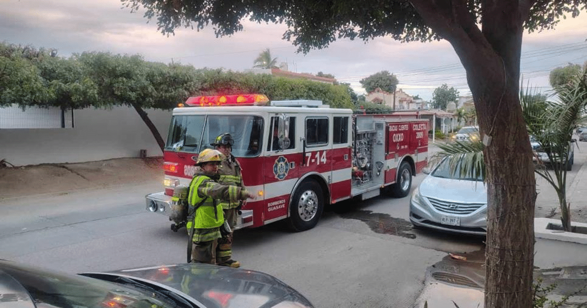 Camión de bomberos con luces encendidas y bomberos en escena tras incendio en consultorio dental en Guasave.