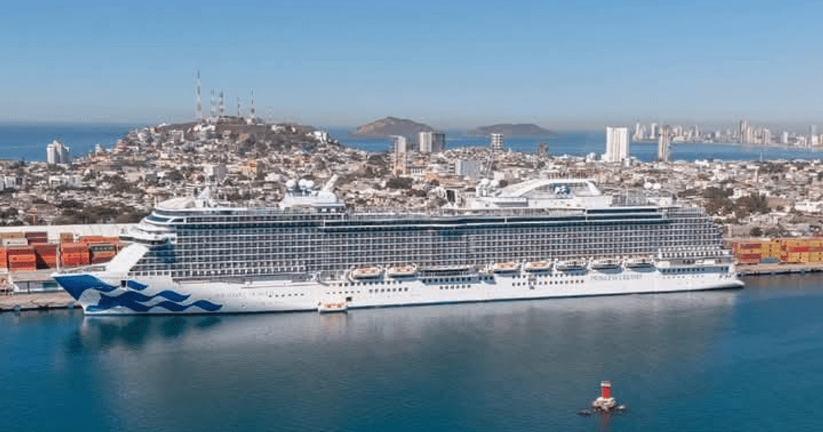 Crucero Discovery Princess en el puerto de Mazatlán con paisaje urbano y montañas al fondo.