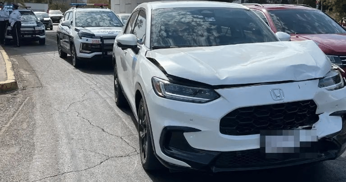 Coche blanco dañado en accidente vial en Culiacán, rodeado de patrullas policiales.