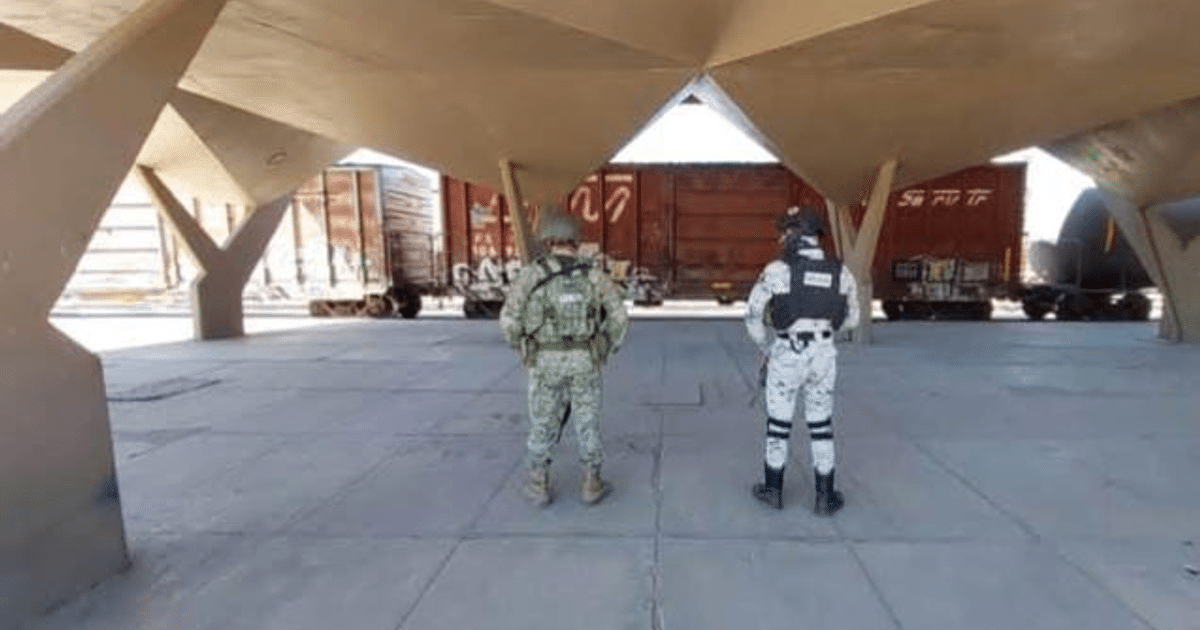 Soldados en uniforme observan tren de carga en operativo de seguridad en Estación Sufragio.