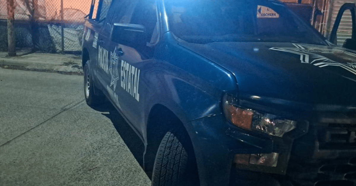 Camioneta de la Policía Estatal con luces azules en cochera durante la noche