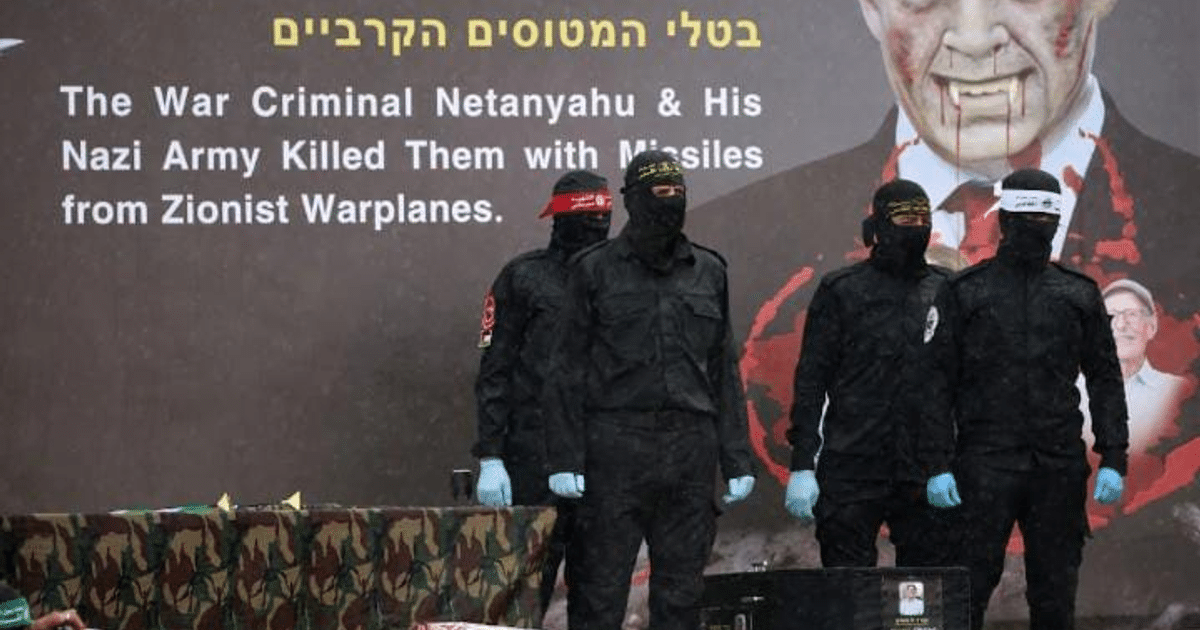 Personas enmascaradas frente a cartel crítico sobre Netanyahu y conflicto