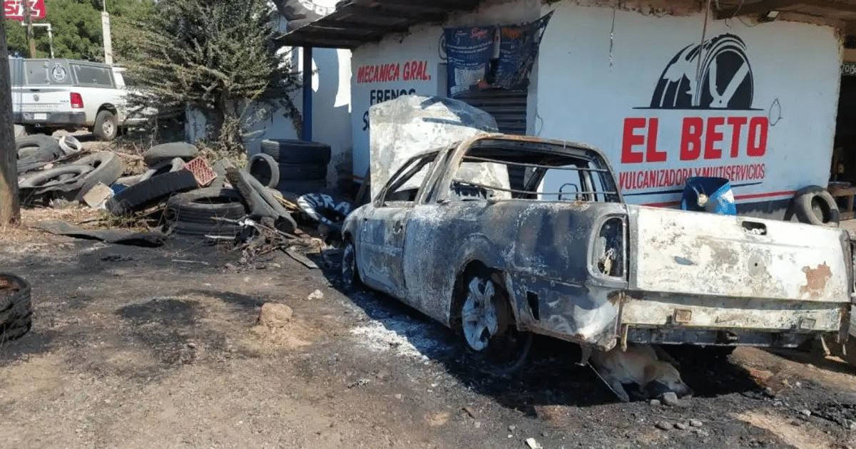 Taller mecánico con vehículo quemado y daños tras enfrentamiento en Culiacán.