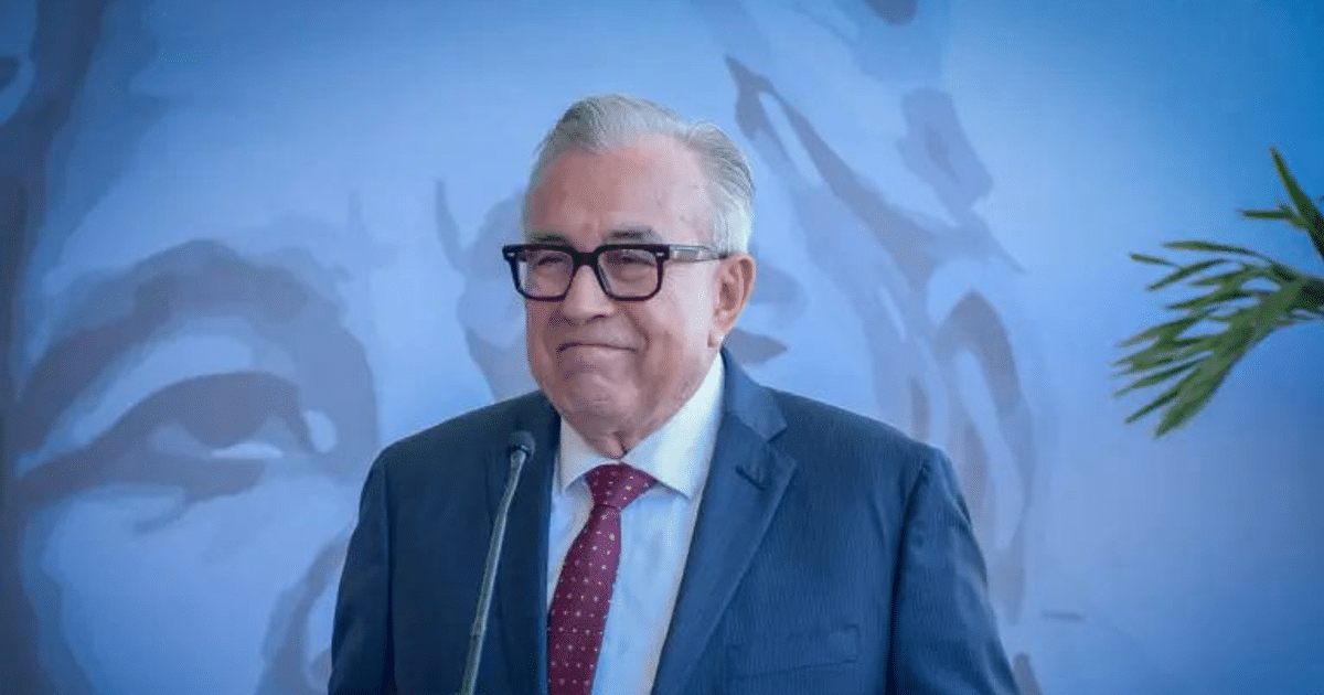 Persona sonriendo en reunión política en Culiacán con micrófono y gráfico de fondo