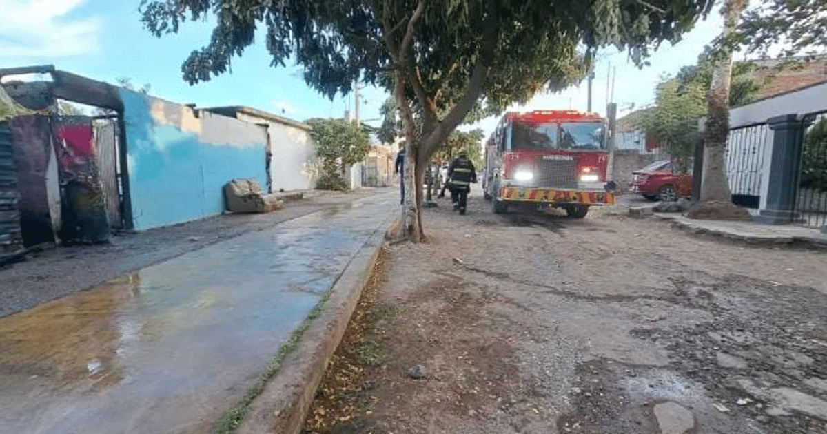 Camión de bomberos y bomberos en acción en una calle de tierra en Culiacán, Sinaloa.