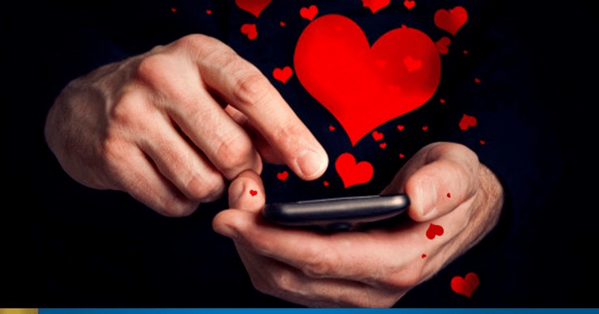 Manos sosteniendo un teléfono móvil con corazones rojos emergiendo de la pantalla, simbolizando el amor digital.
