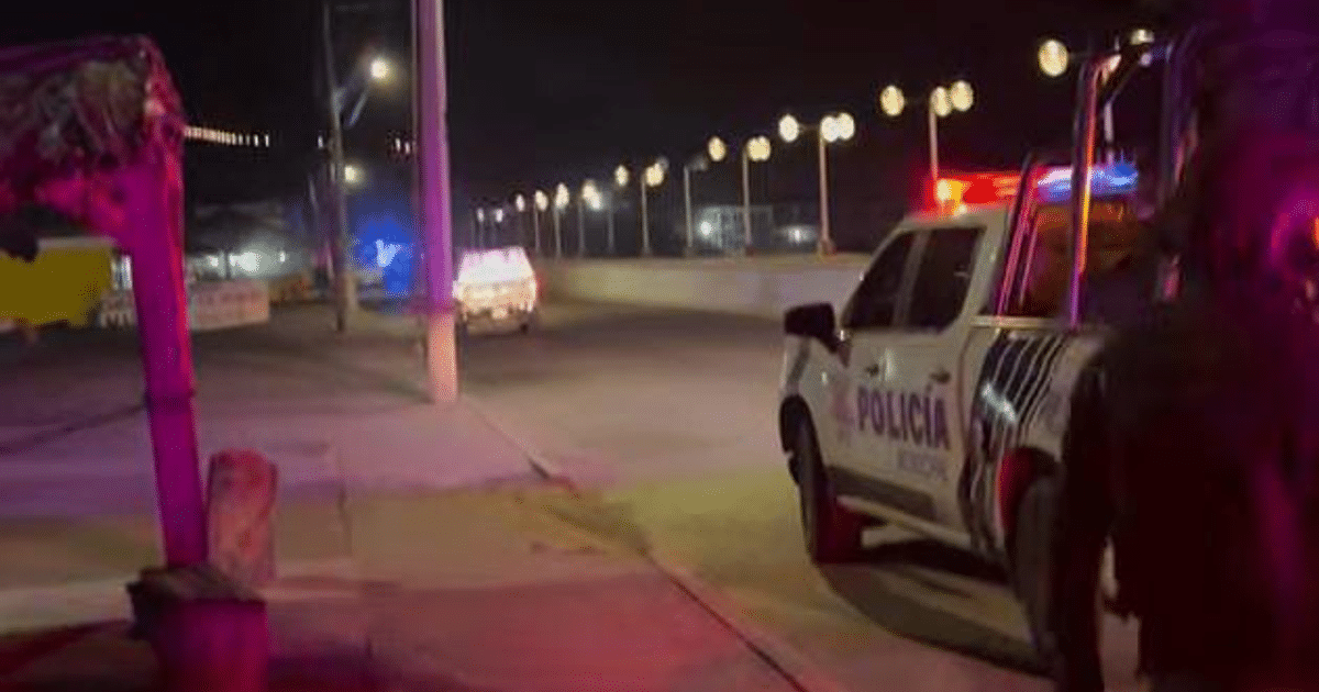 Vehículo de policía con luces de emergencia en una calle desierta de Mazatlán durante la noche.