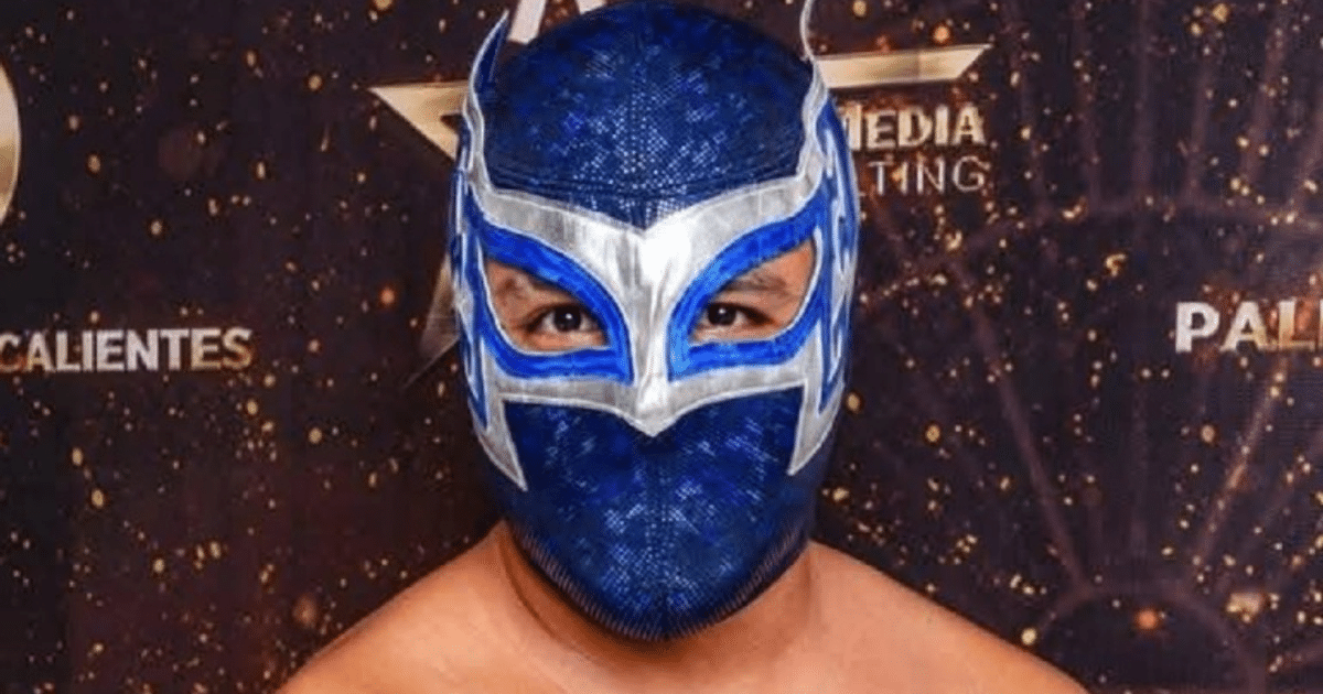 Luchador Misterius con máscara azul y detalles en plata en evento de lucha libre