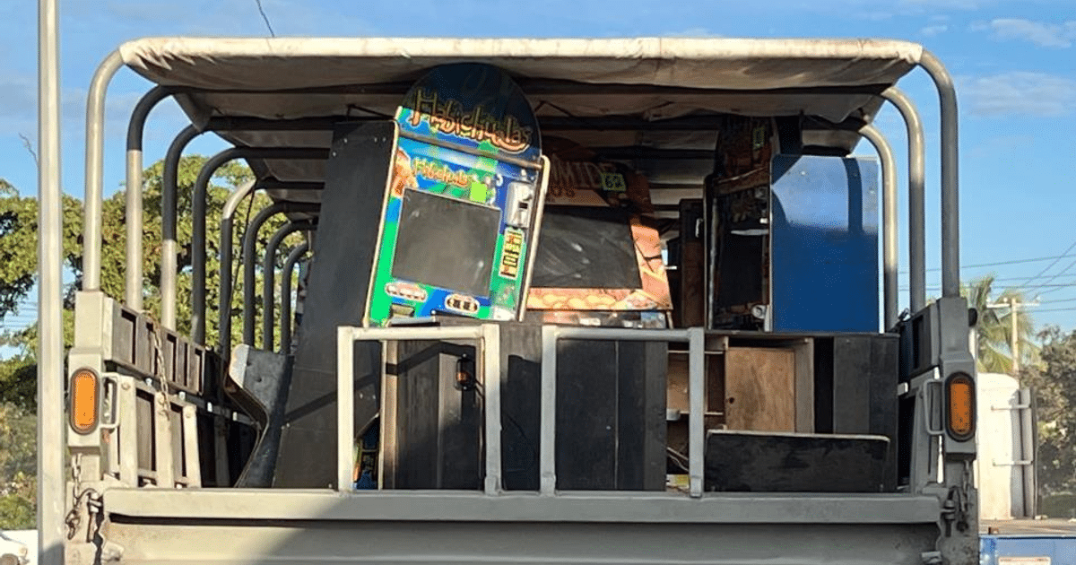 Vehículo transportando máquinas de juego decomisadas en Mazatlán, con cielo despejado y vegetación al fondo.