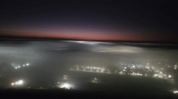 Escena nocturna con niebla densa y luces urbanas en Sinaloa