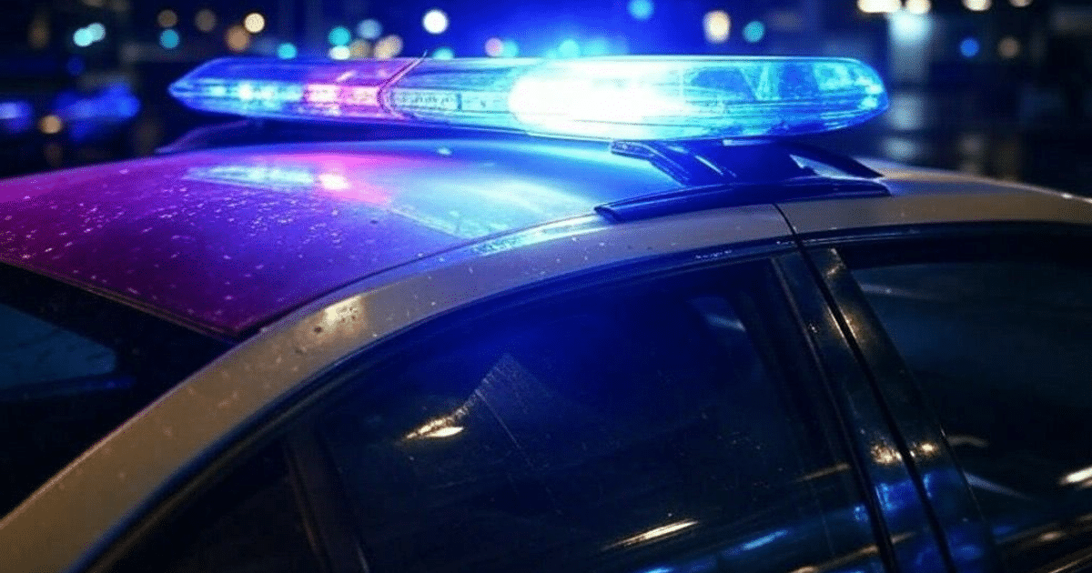 Vehículo policial con luces de emergencia encendidas en un operativo en Mazatlán, Sinaloa, con gotas de agua visibles en la superficie.