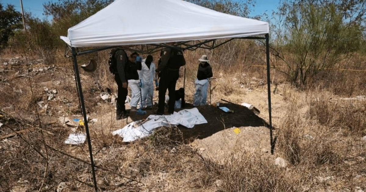 Equipo forense trabajando bajo una carpa en Culiacán, investigando restos óseos en un entorno seco.