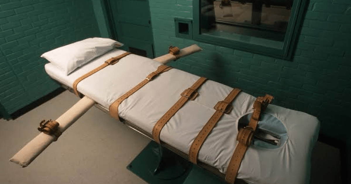 Cama de restricción con correas de cuero en un entorno institucional de paredes verdes.